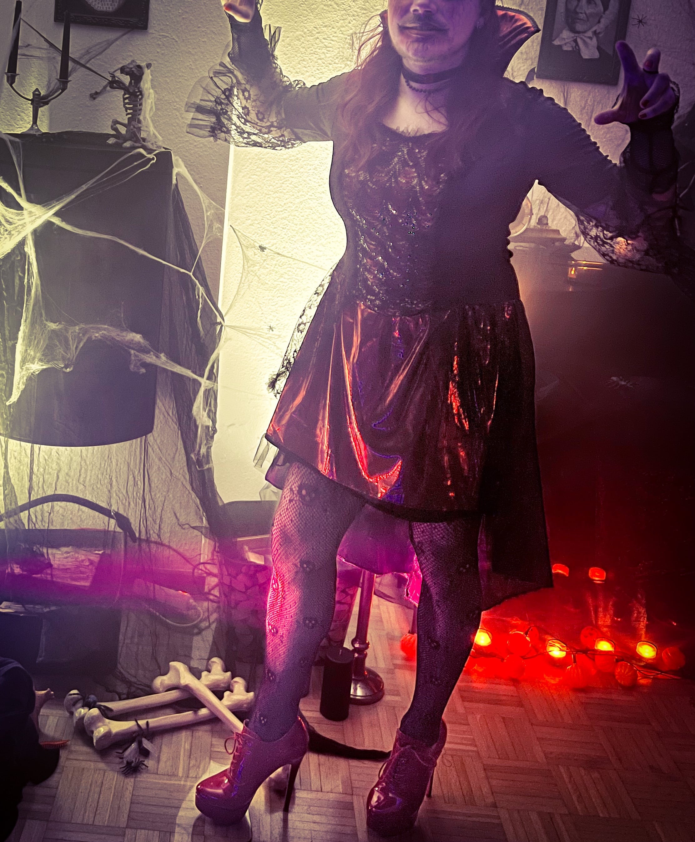 Man dressed as a vampire for Halloween, in a black dress with dramatic makeup